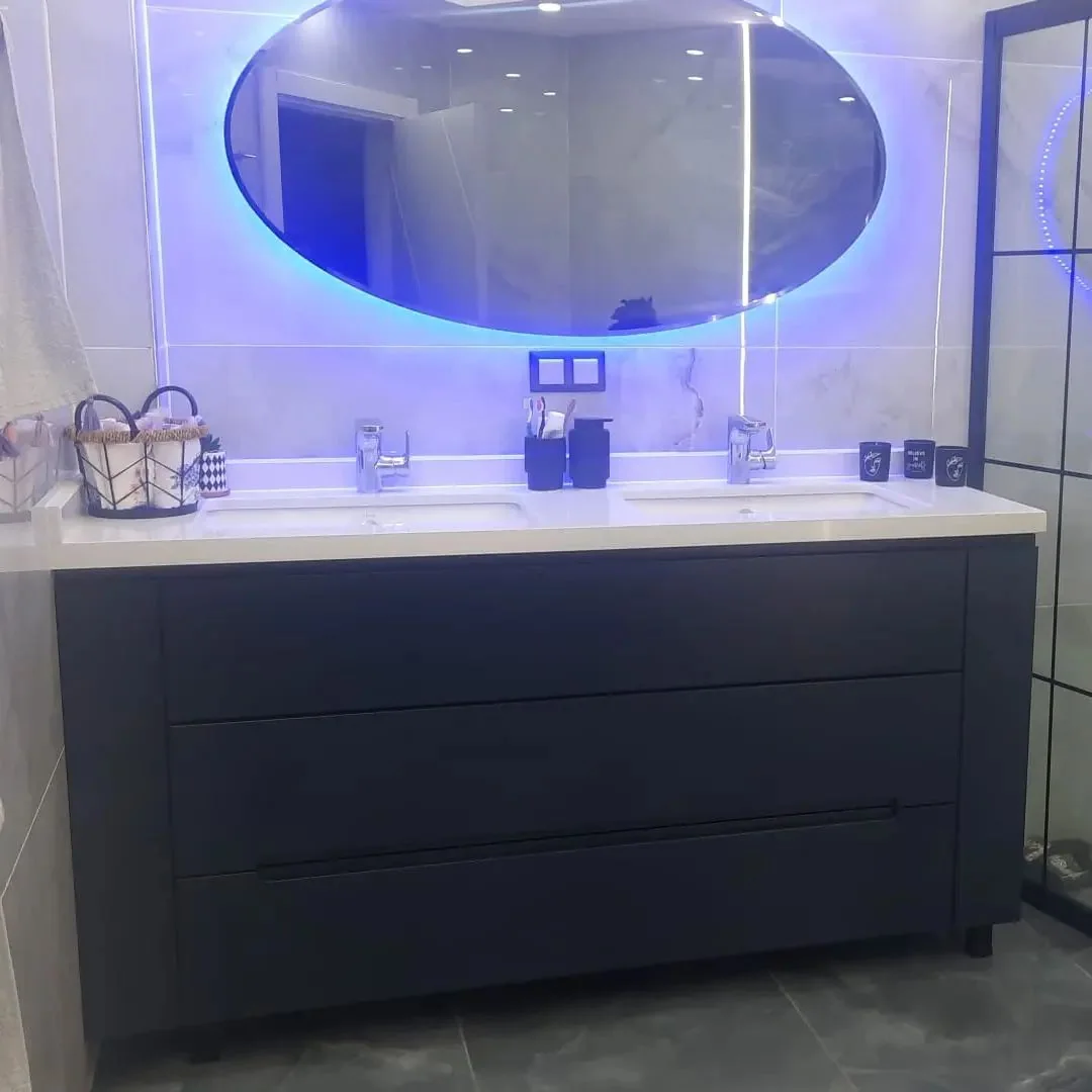 Mavi ayna aydınlatması ve koyu renk çekmeceli banyo dolabı