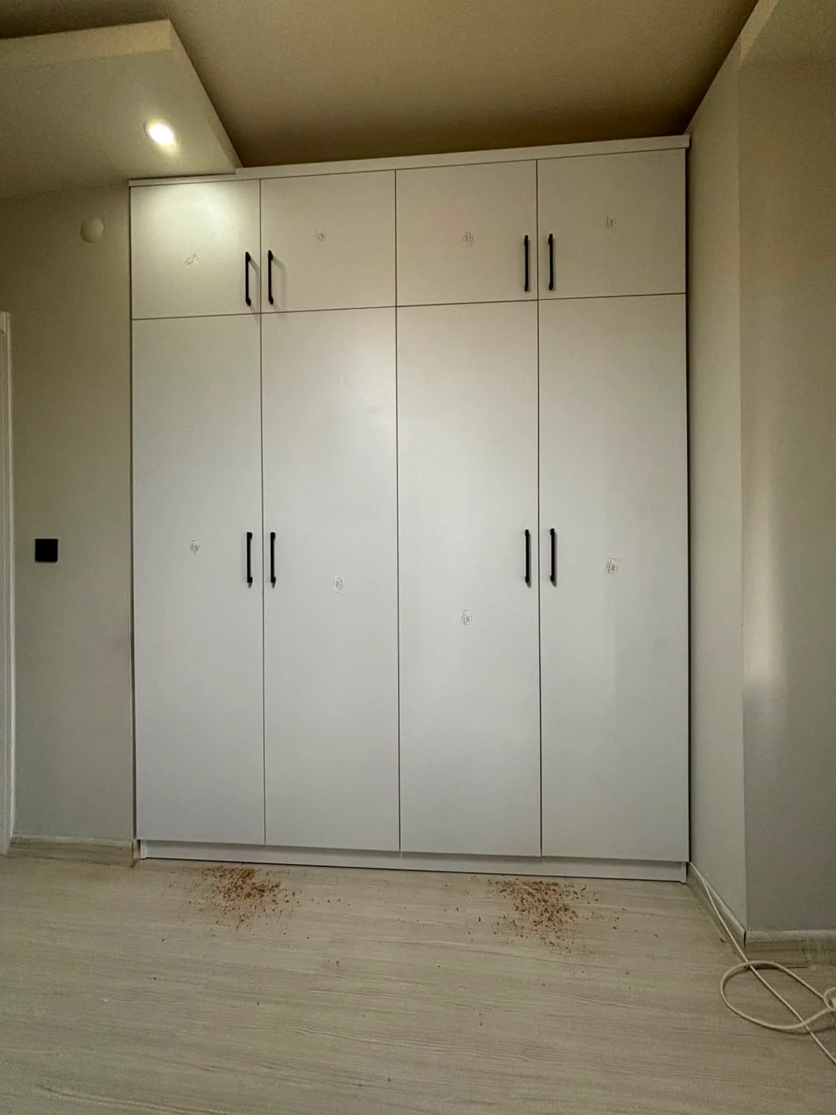 Tavana kadar uzanan beyaz kapaklı gardırop uygulaması